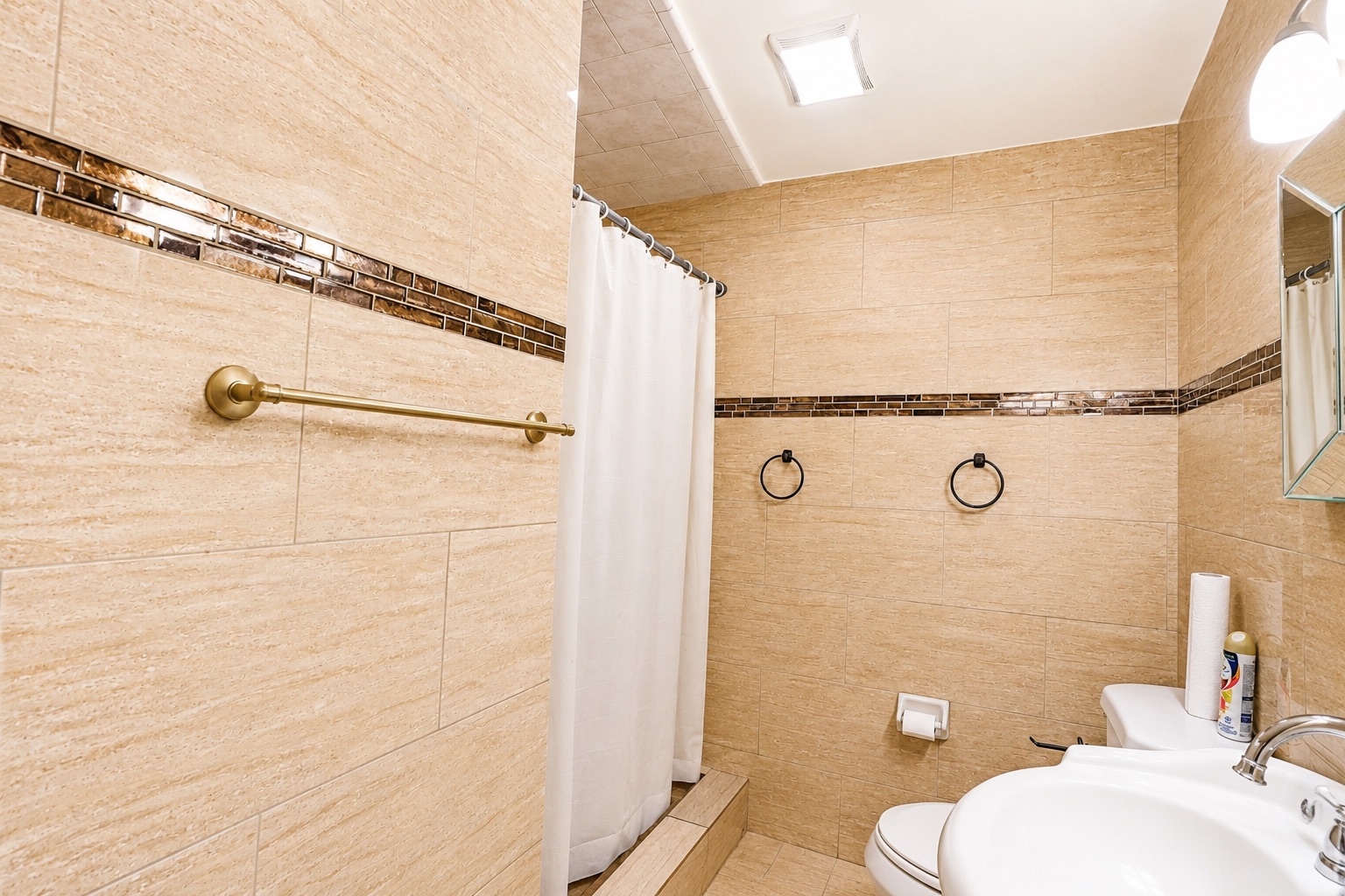 1508 Walnut Street Georgetown, TX 78626 - Photo 11 of 37 Textured tile walls with a mosaic accent band create a cohesive and clean bathroom space.