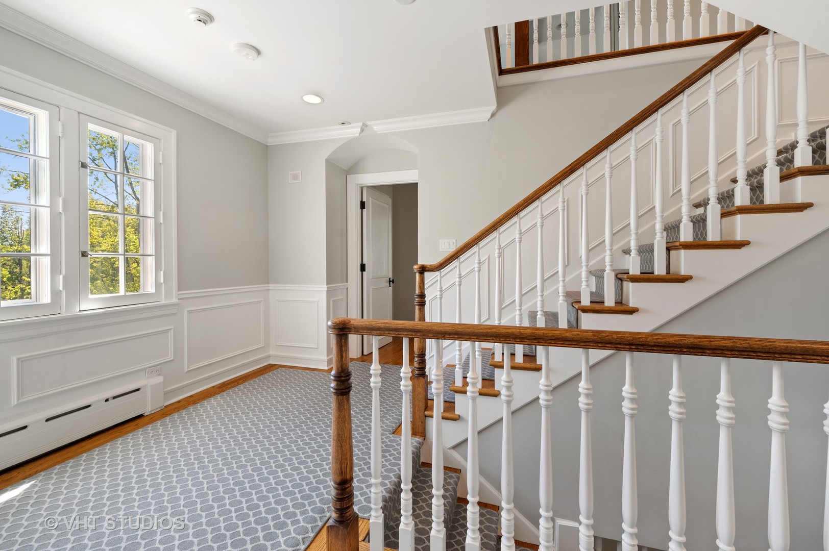 92 Robsart Road Kenilworth, IL 60043 - Photo 33 of 54 a view of staircase with lots of frames on wall and a window