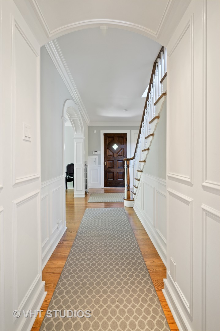 92 Robsart Road Kenilworth, IL 60043 - Photo 10 of 54 a hallway with wooden floor windows and stairs