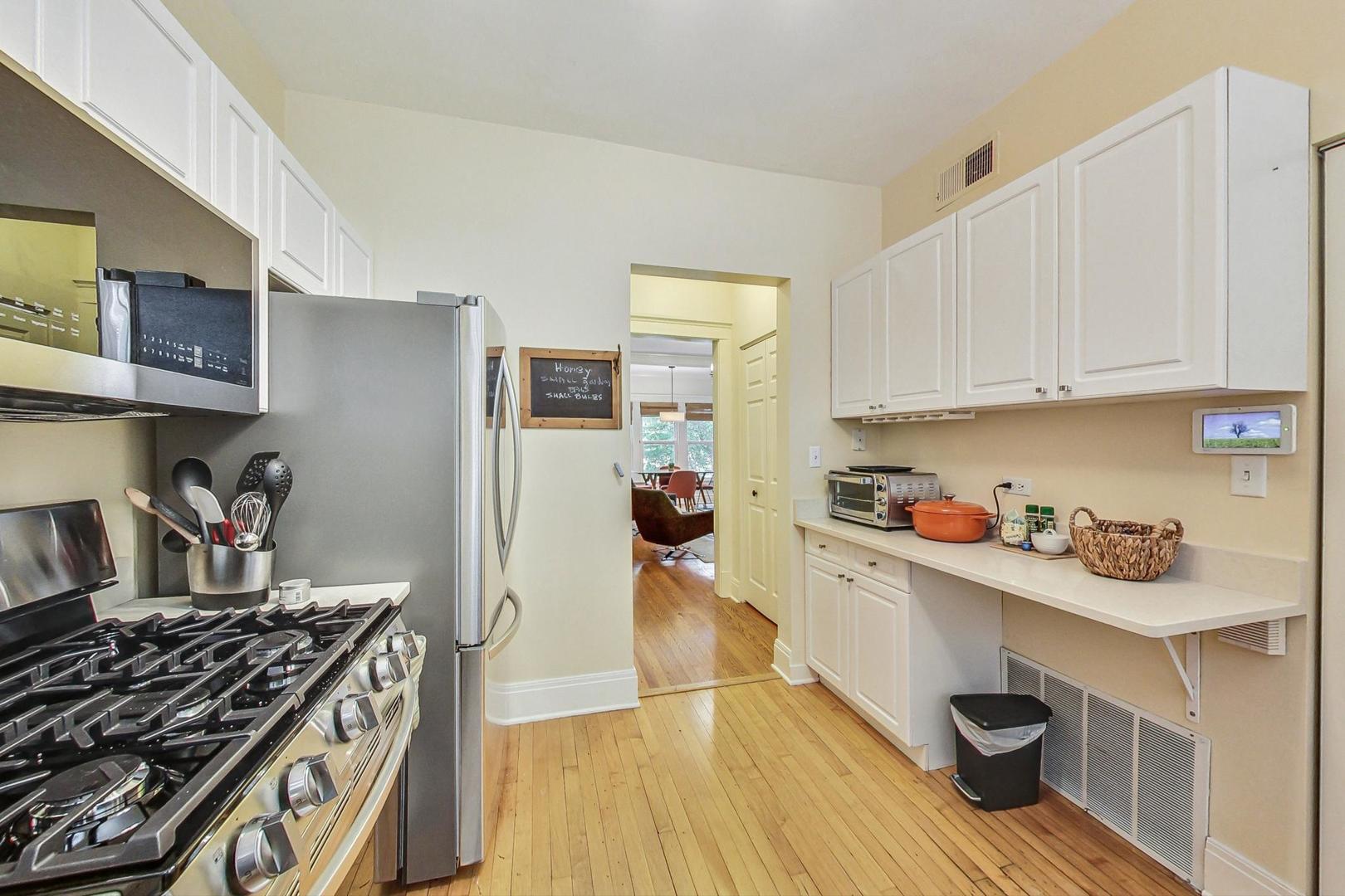 733 West Buckingham Place, Unit 13 Chicago, IL 60657 - Photo 12 of 28 a kitchen with granite countertop a stove and a wooden floor