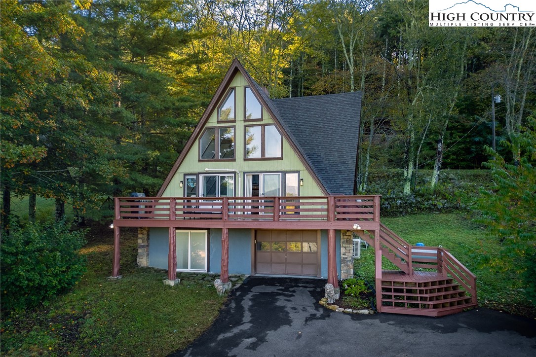 209 Apache Street Newland, NC 28657 - Photo 1 of 42 a view of a wooden house with a big yard and large trees