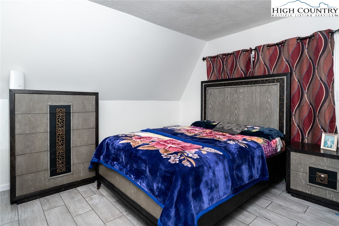 209 Apache Street Newland, NC 28657 - Photo 30 of 42 a bedroom with a bed and a painting on the wall