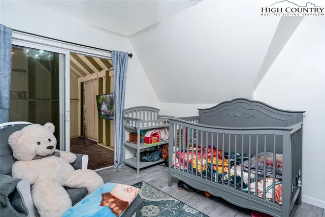 a bedroom with baby crib and a window