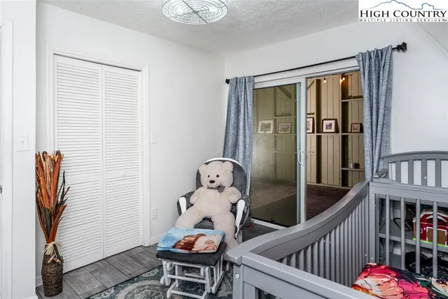 a view of a hallway with wooden floor and windows