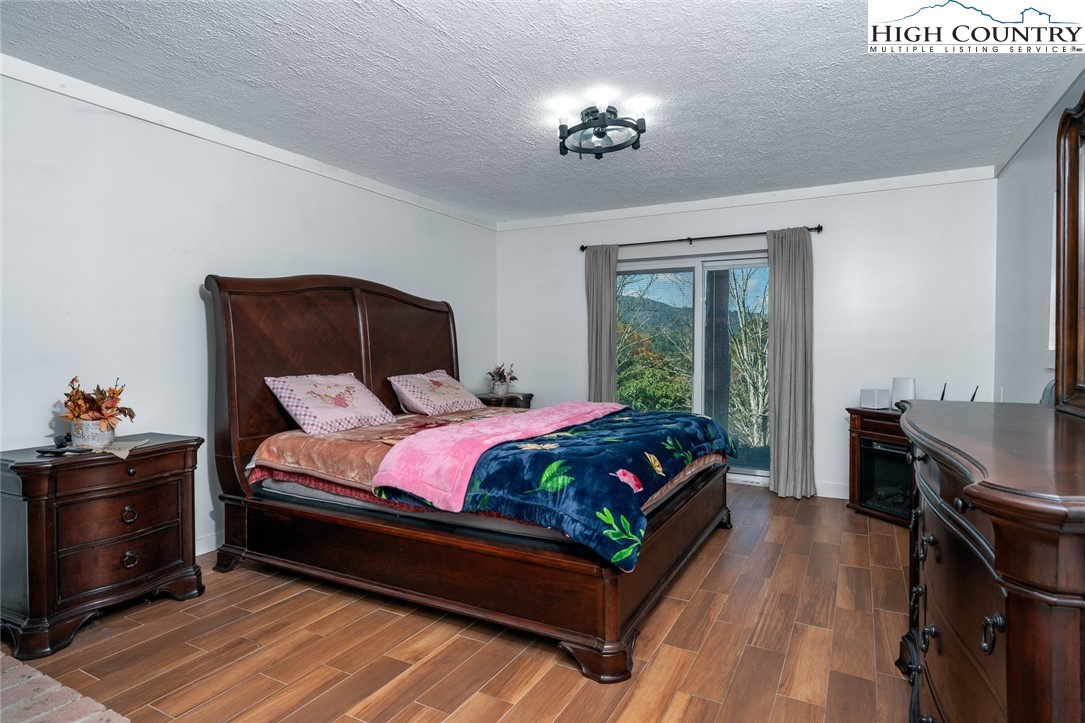 209 Apache Street Newland, NC 28657 - Photo 35 of 42 a bedroom with a bed and wooden floor