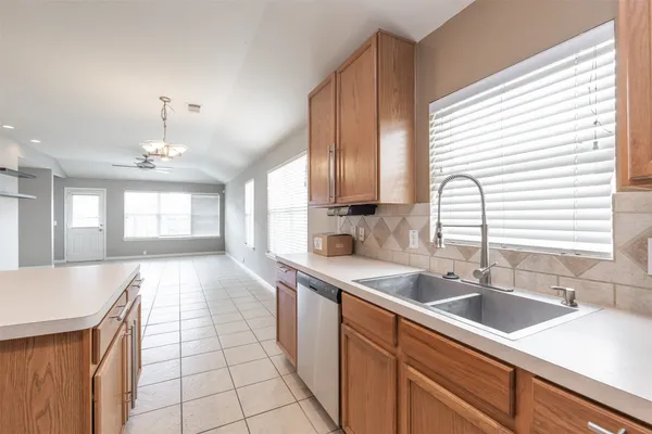 a large kitchen with kitchen island a sink a counter space and a window