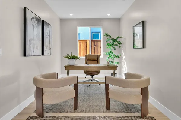 a living room with couches a potted plant and a window