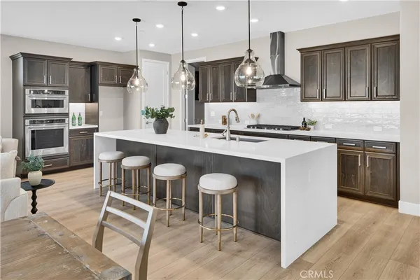 a kitchen with stainless steel appliances granite countertop a stove a sink and a refrigerator