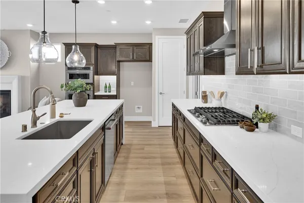 a kitchen with stainless steel appliances granite countertop a sink a stove and a refrigerator