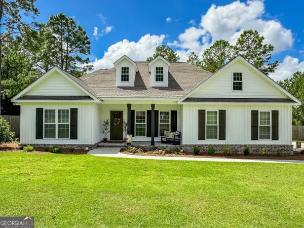 a front view of a house with a yard and outdoor seating