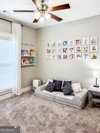 a living room with furniture and a baby crib