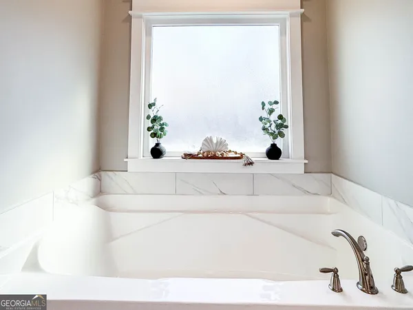 a bath tub sitting in a bathroom next to a window