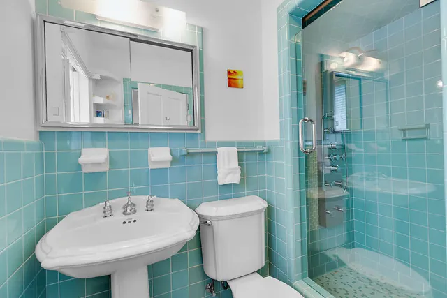 a bathroom with a sink a toilet and shower