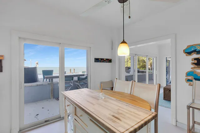 a dining room with a table chairs and a kitchen view