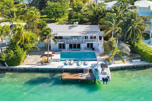 an aerial view of a house with a garden and lake view