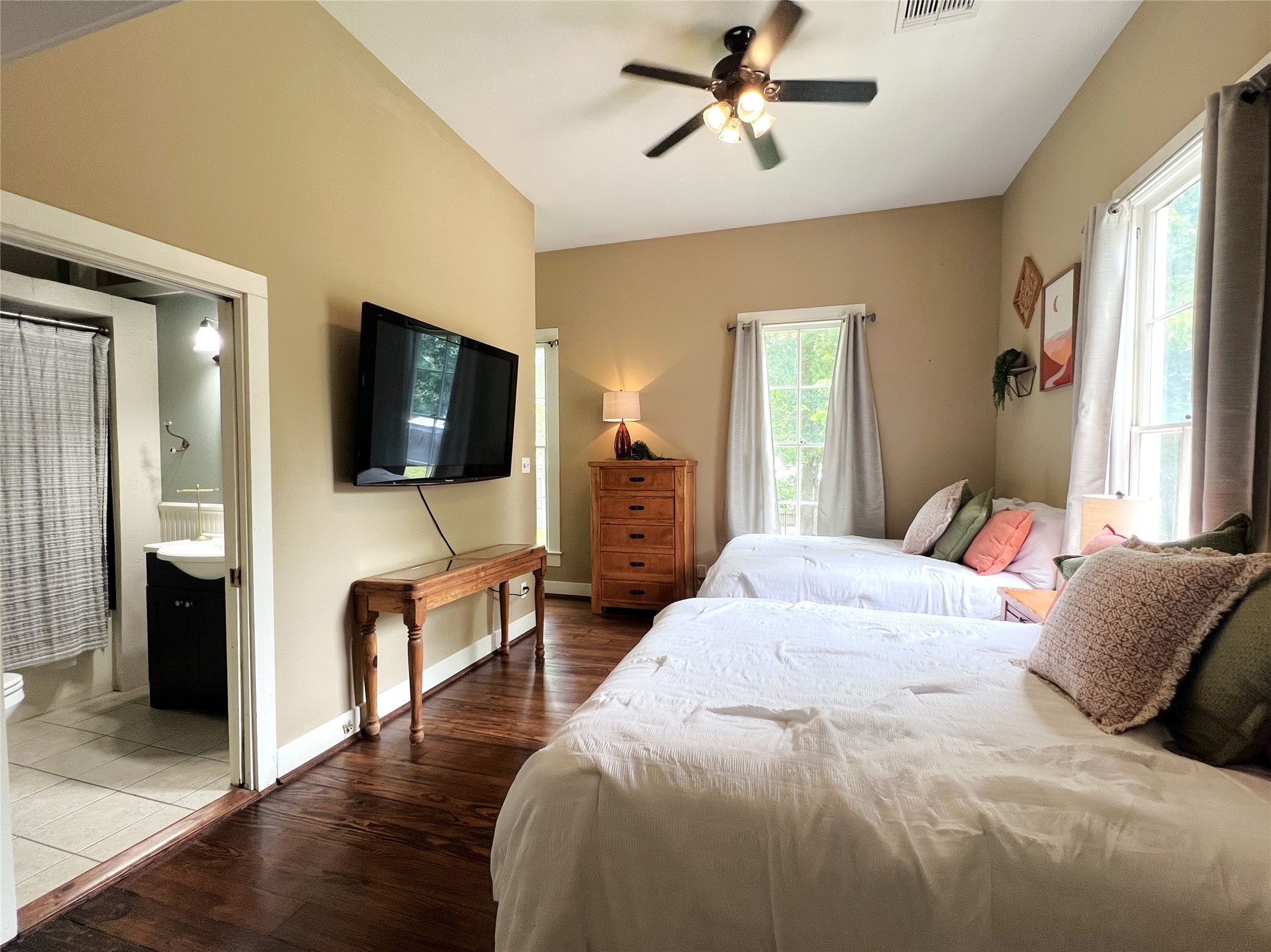 606 Sycamore Street Brenham, TX 77833 - Photo 17 of 27 a bedroom with a bed and a flat tv screen on wall