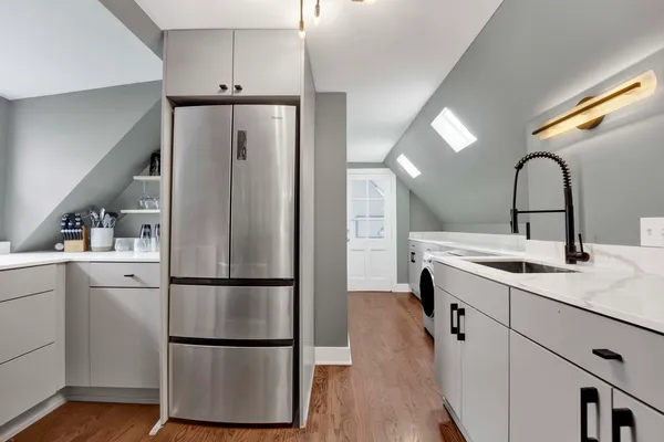 a kitchen with kitchen island a sink appliances and cabinets
