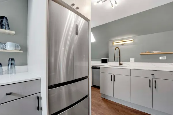 a kitchen with a refrigerator sink and cabinets