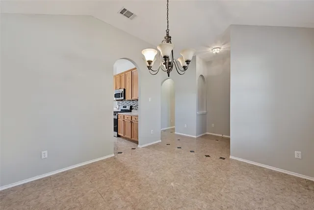 a view of a chandelier fan and refrigerator in a room