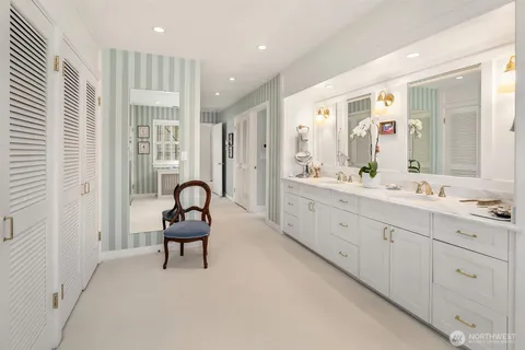 a spacious bathroom with double vanity a mirror and a shower