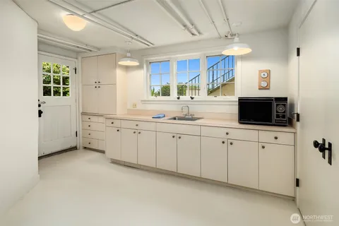 a kitchen with cabinets stainless steel appliances a sink and a window