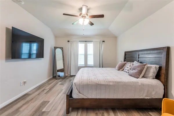 a bedroom with a large bed and a chandelier