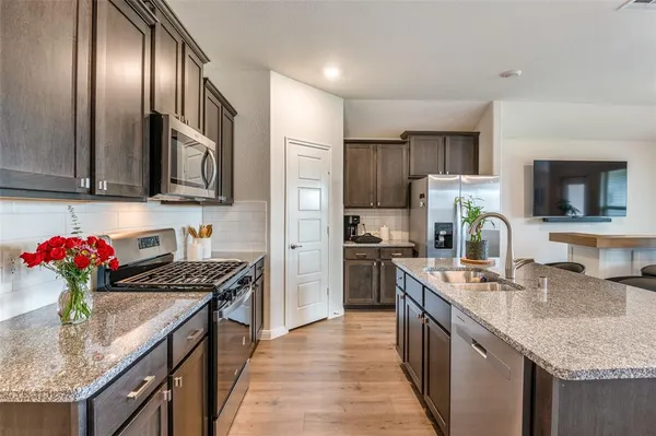a kitchen with granite countertop stainless steel appliances and wooden cabinets