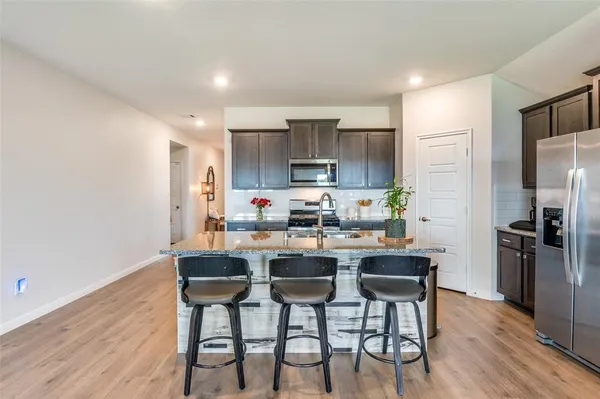 a kitchen with refrigerator and chairs