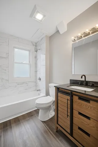 a bathroom with a sink a toilet a mirror and shower