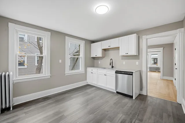 a kitchen with granite countertop white cabinets and white appliances