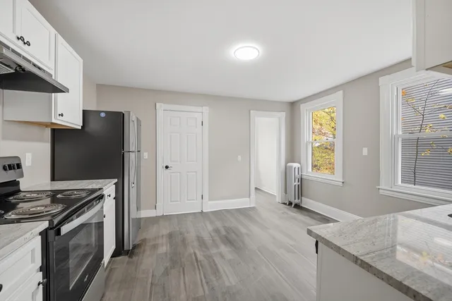 a kitchen with granite countertop a stove refrigerator and microwave