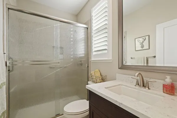 a bathroom with a sink toilet vanity and shower