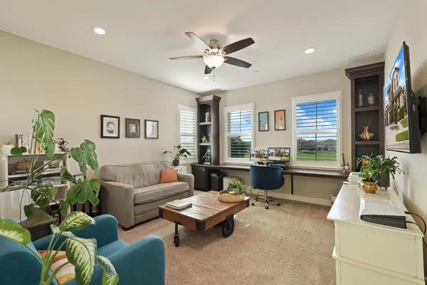 a living room with furniture ceiling fan and a window
