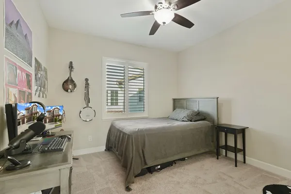 a bedroom with a bed and a flat tv screen on dresser