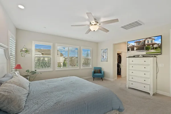 a spacious bedroom with a bed and wooden floor