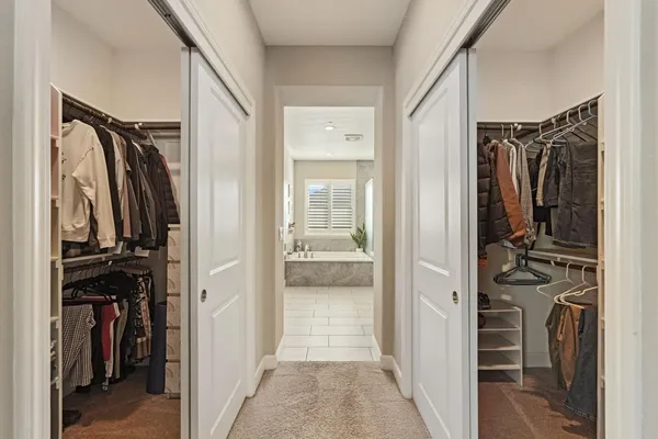 a view of walk in closet with clothes and shoes