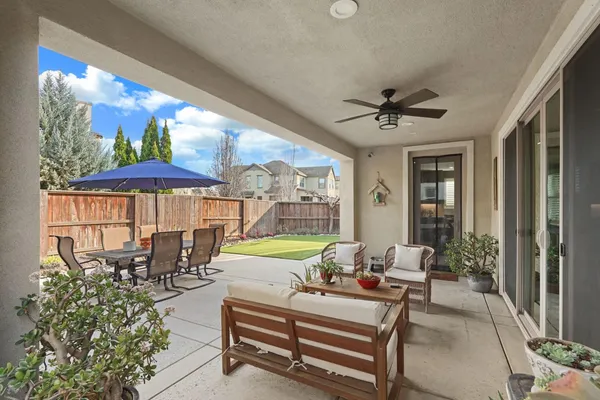 a living room with furniture a chandelier and a floor to ceiling window