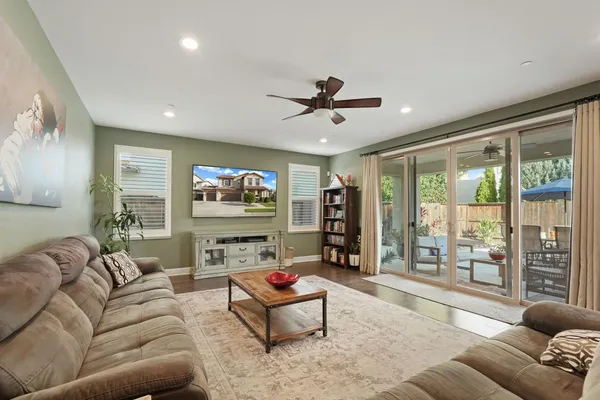 a living room with furniture a floor to ceiling window and a flat screen tv