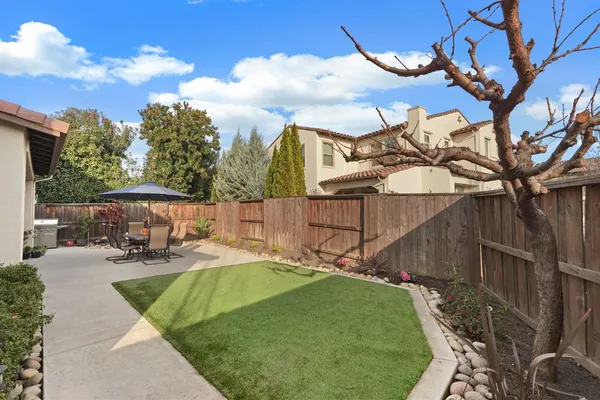 a view of a patio with table and chairs under an umbrella