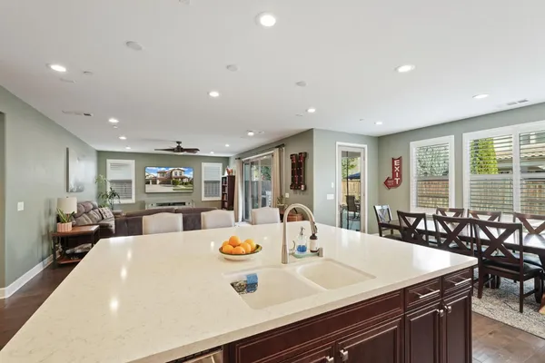 a large kitchen with a large counter top furniture a dining table and chairs