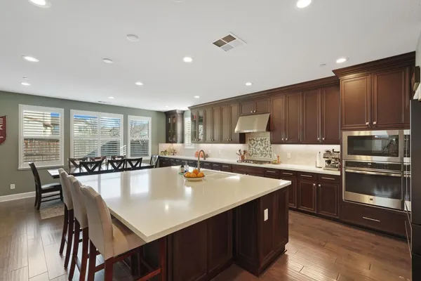a large kitchen with lots of counter space a sink appliances and dining table