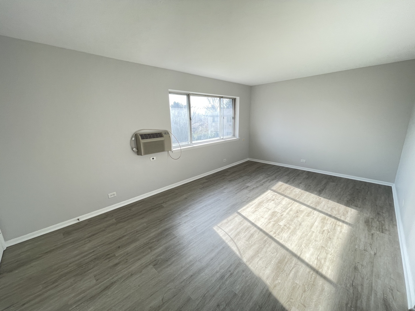 235 East Palatine Road, Unit 2B Palatine, IL 60067 - Photo 2 of 12 an empty room with wooden floor and windows