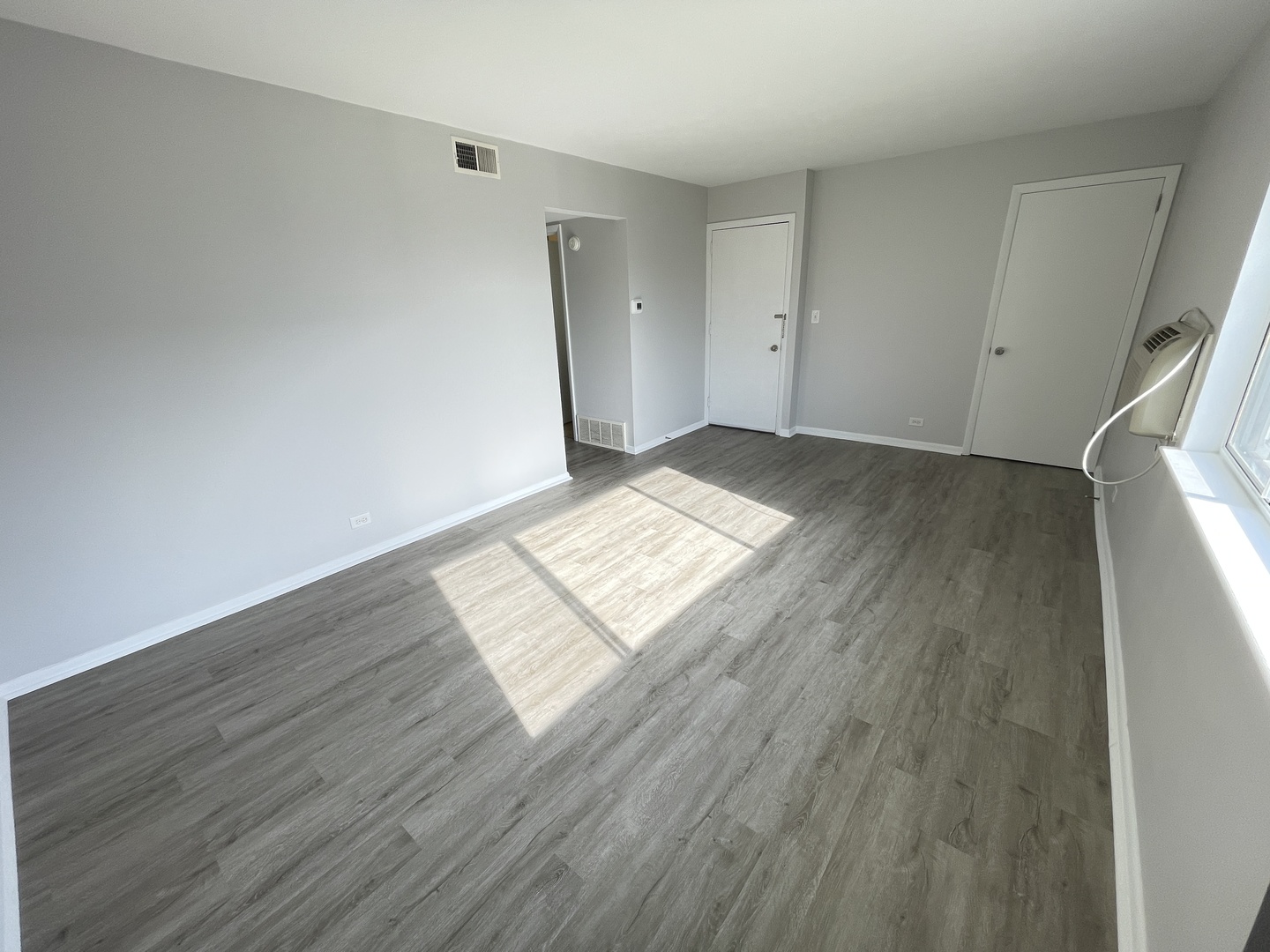 235 East Palatine Road, Unit 2B Palatine, IL 60067 - Photo 3 of 12 an empty room with wooden floor and windows