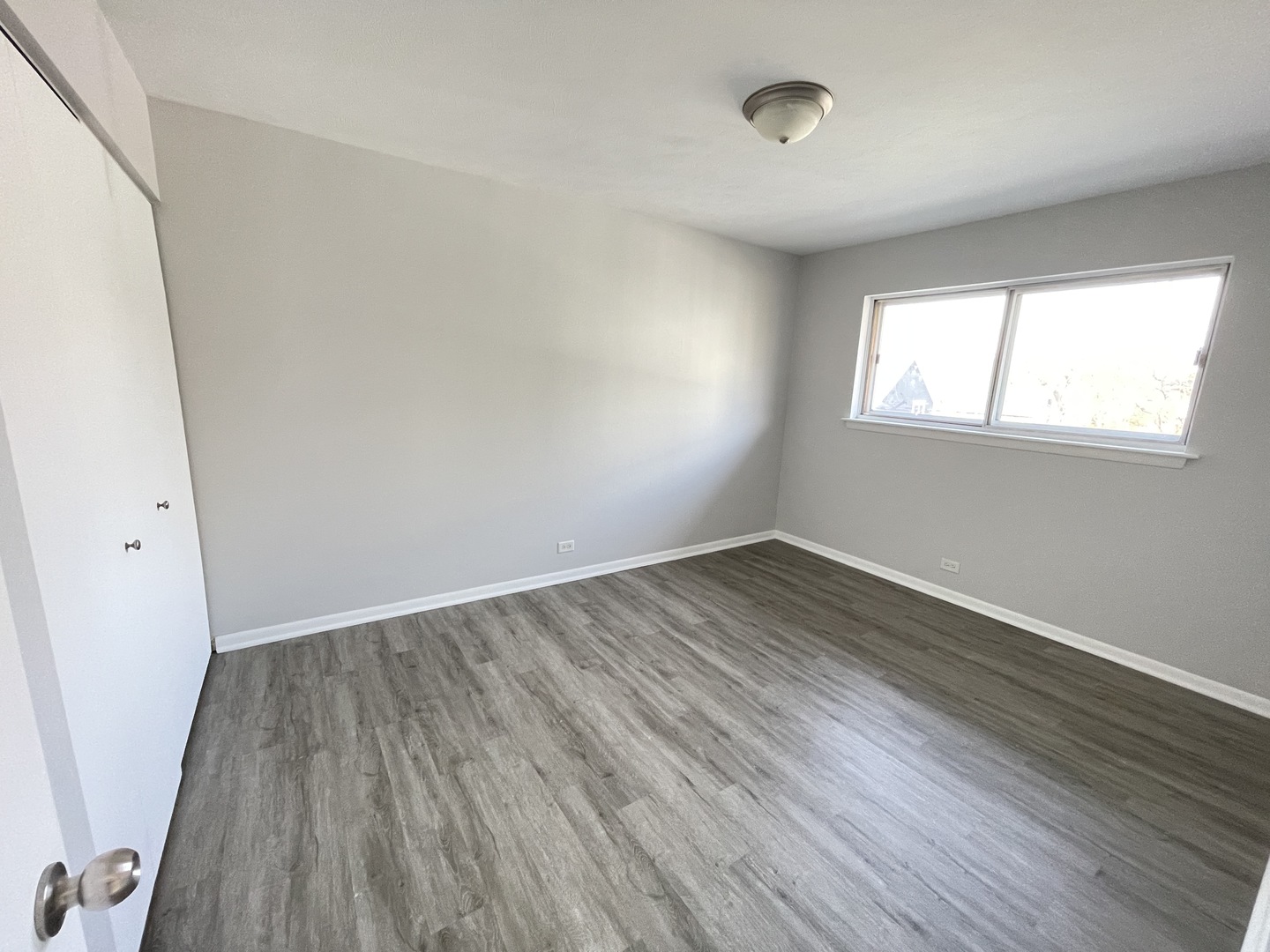 235 East Palatine Road, Unit 2B Palatine, IL 60067 - Photo 4 of 12 an empty room with wooden floor and windows
