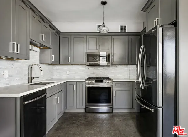 a kitchen with white cabinets a sink stove and a granite counter top