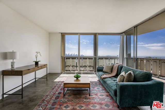 a living room with furniture and a floor to ceiling window