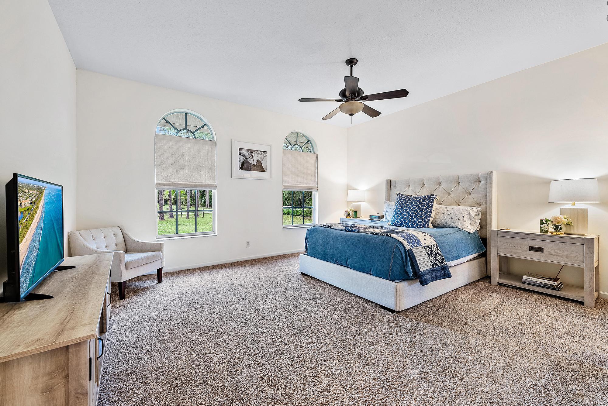 15644 Billy Goat Lane Jupiter, FL 33478 - Photo 16 of 39 a spacious bedroom with a bed a couch and a window