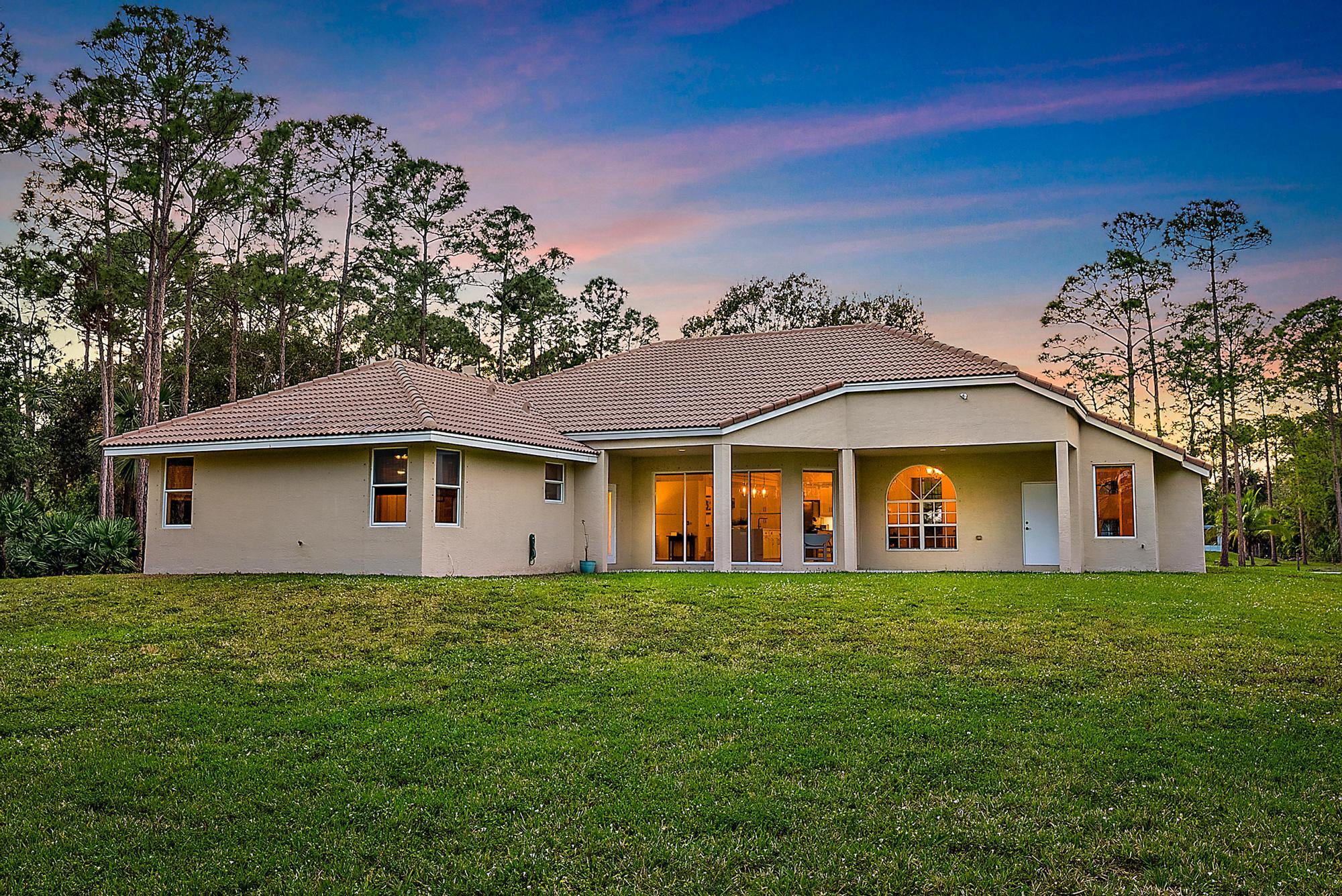 15644 Billy Goat Lane Jupiter, FL 33478 - Photo 29 of 39 a big house with a big yard and large trees
