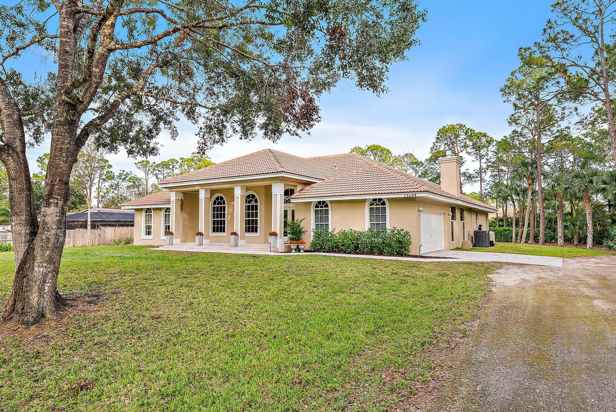 15644 Billy Goat Lane Jupiter, FL 33478 - Photo 4 of 39 front view of a house with a yard