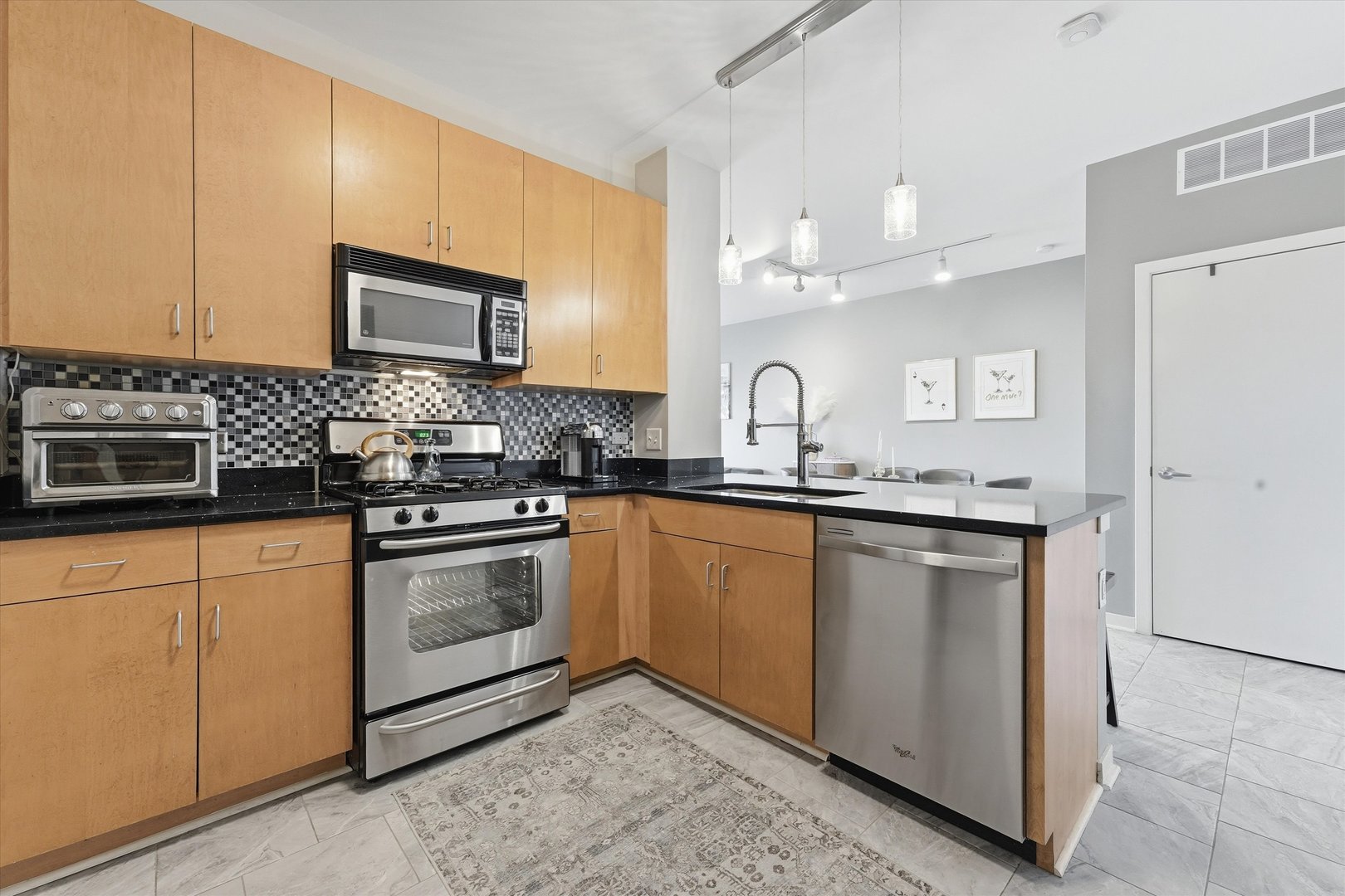 1155 West Roosevelt Road, Unit 404 Chicago, IL 60608 - Photo 6 of 30 a kitchen with stainless steel appliances granite countertop a sink stove and cabinets
